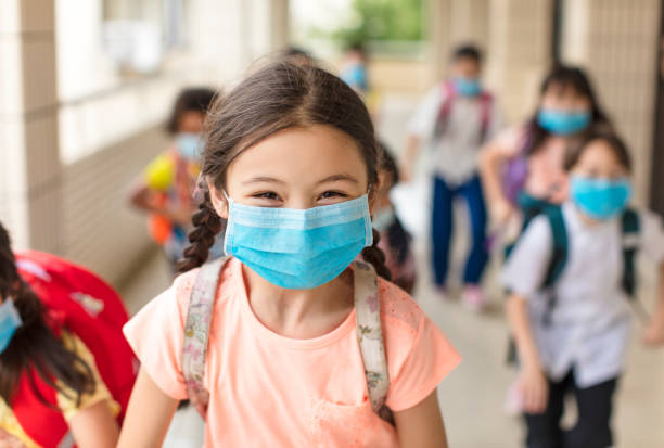   Smiling masked children at school